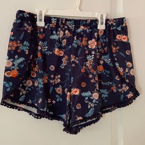 Blue shorts with flowery design and pom pom detail